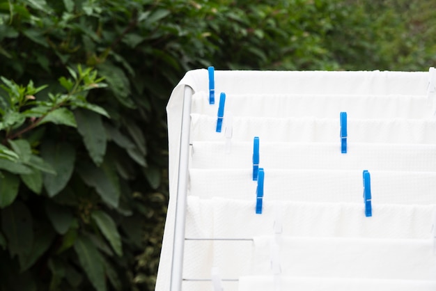 Serviettes blanches qui sèchent sur un étendoir à linge placé en intérieur